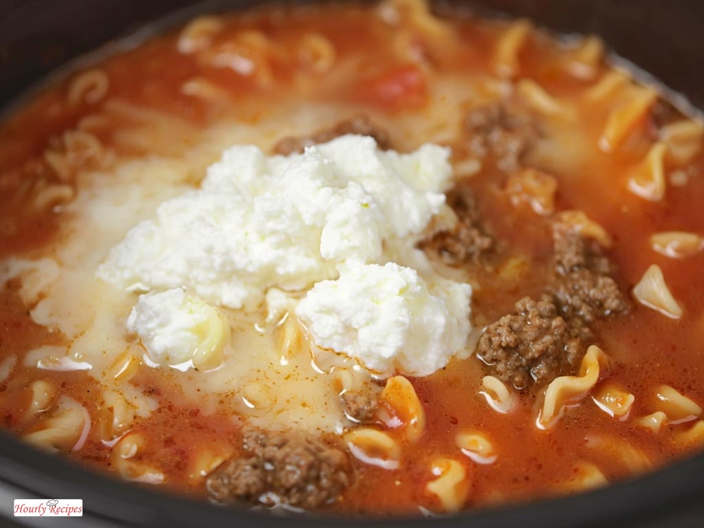 Cheese melting into a creamy lasagna soup in a crock pot, creating a rich and savory dish