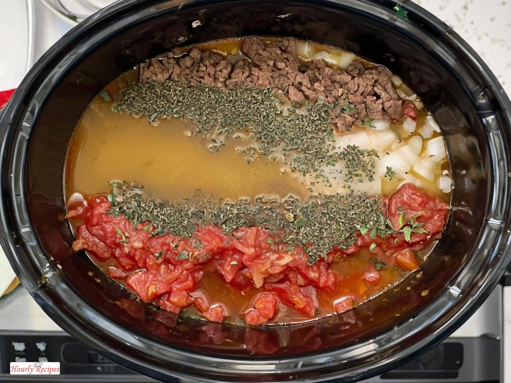 Overhead view of a crock pot filled with fresh ingredients